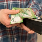 Мужчина пересчитывает деньги в кошельке: деньги